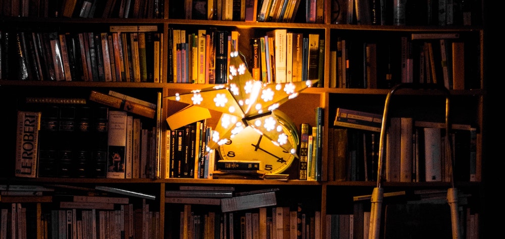 Untidy bookshelves lit by a star-shaped paper light.