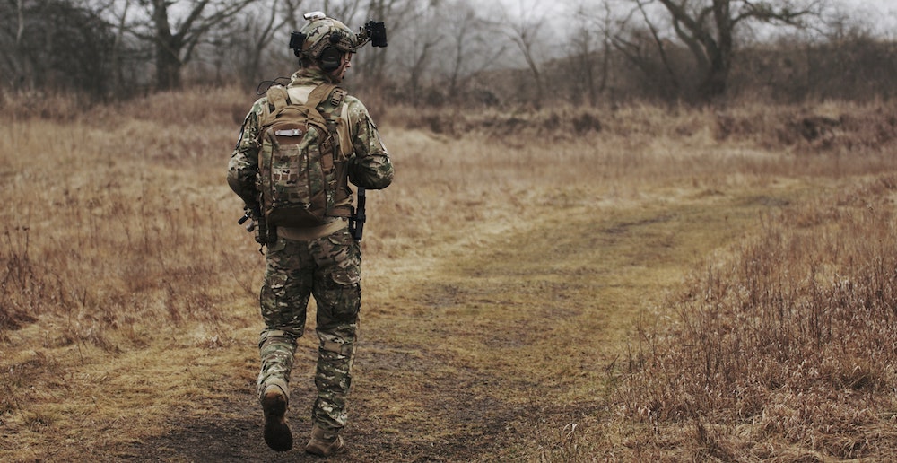 A solitary soldier walking along a rural path