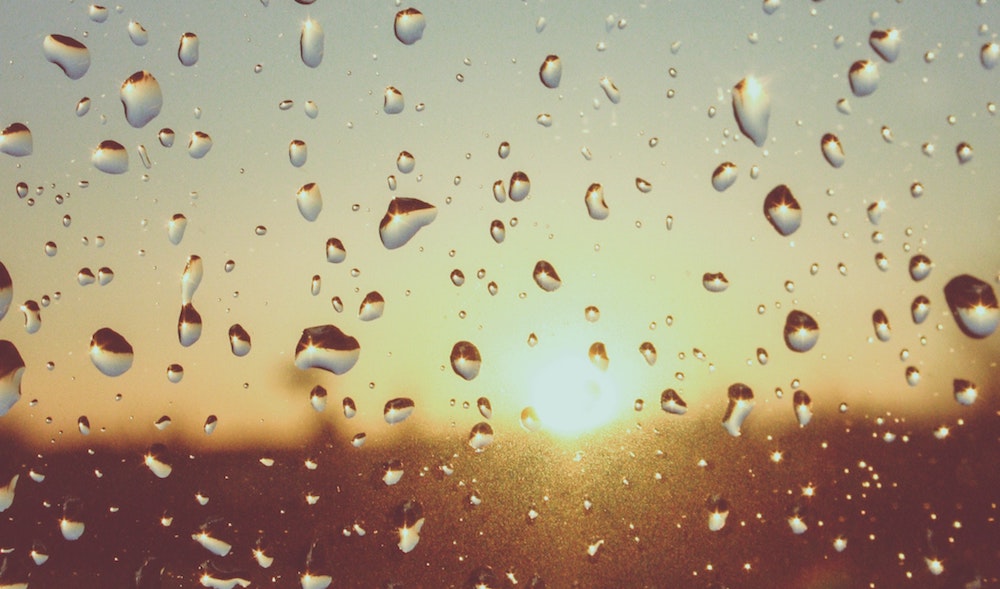 Sunrise seen through a window covered in raindrops